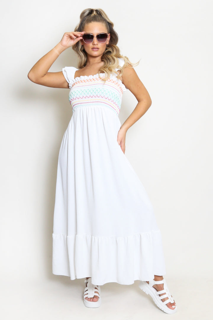 Model in white strappy summer maxi dress with multicolour shirred lines on bodice 